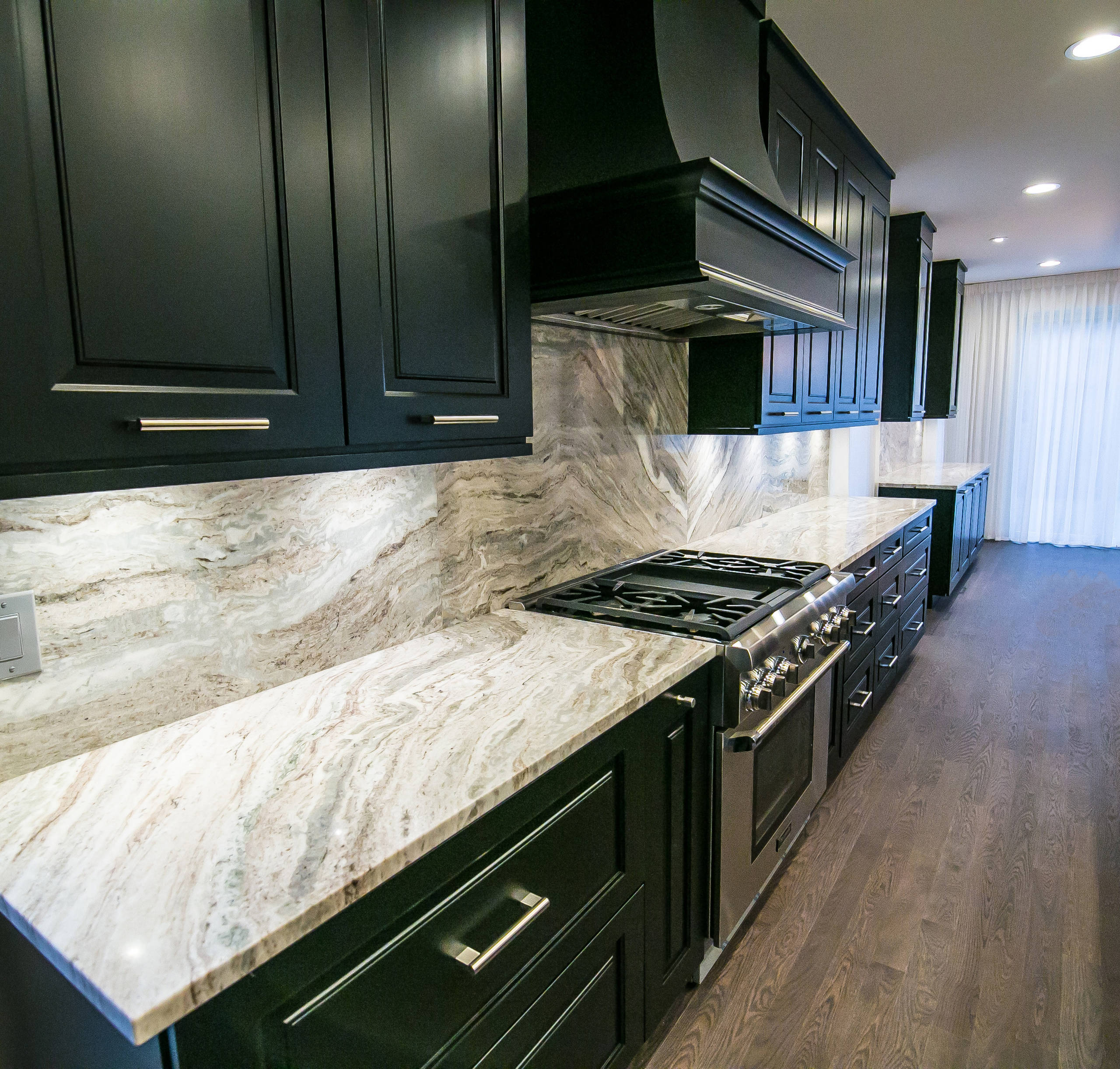 The desire for a modern, yet luxurious, aesthetic inspired a specific attention to detail and material for this home in Huntington Woods. Custom black cabinetry, Fantasy Brown quartzite and stainless