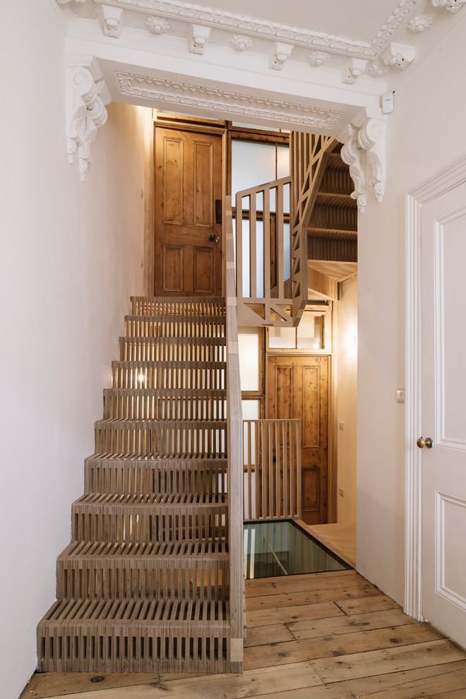 Inspiration for a scandinavian wood u-shaped staircase in London with wood risers and wood railing.
