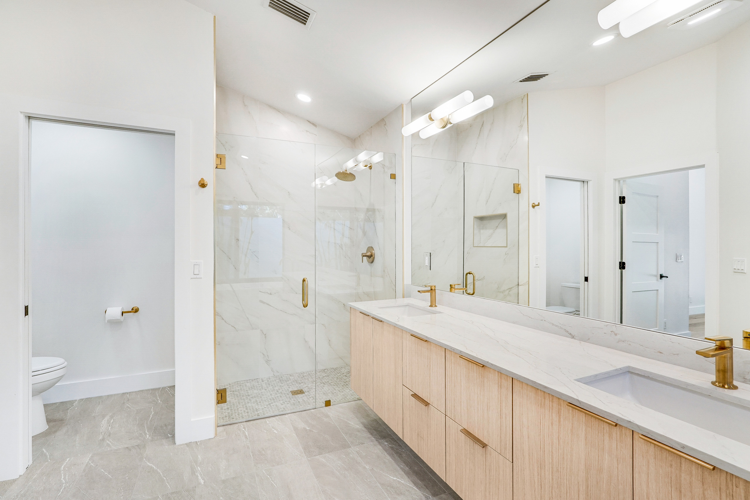 master shower with large format porcelain tiles for easy cleaning