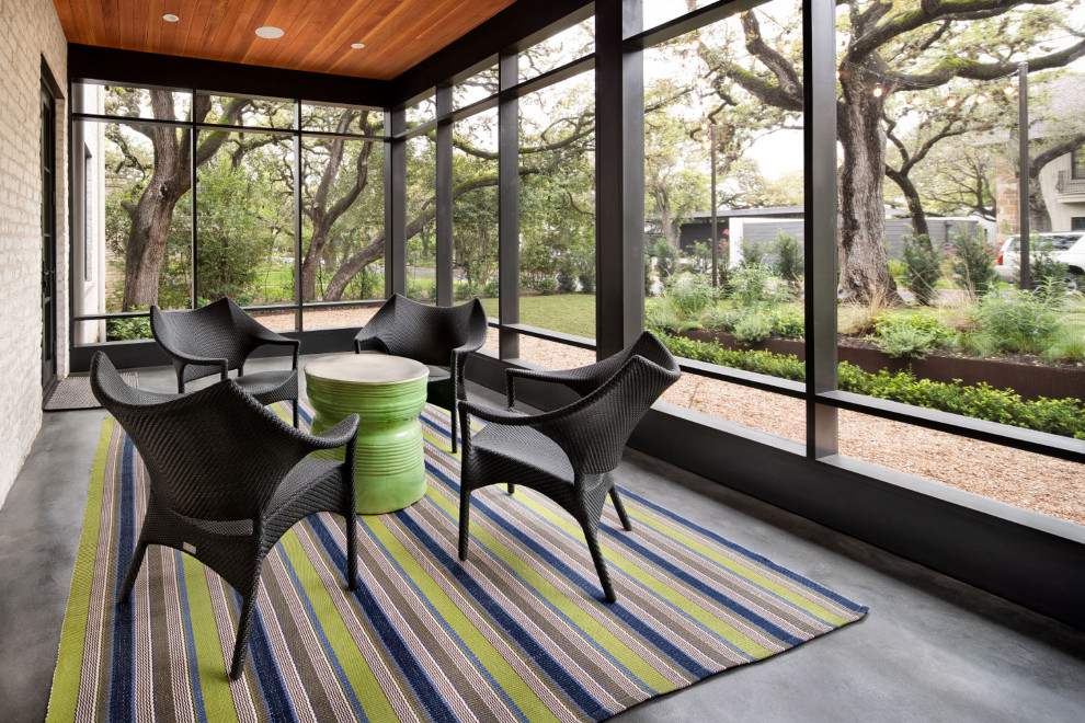 Photo of a mid-sized contemporary front yard screened-in verandah in Austin with concrete slab and a roof extension.