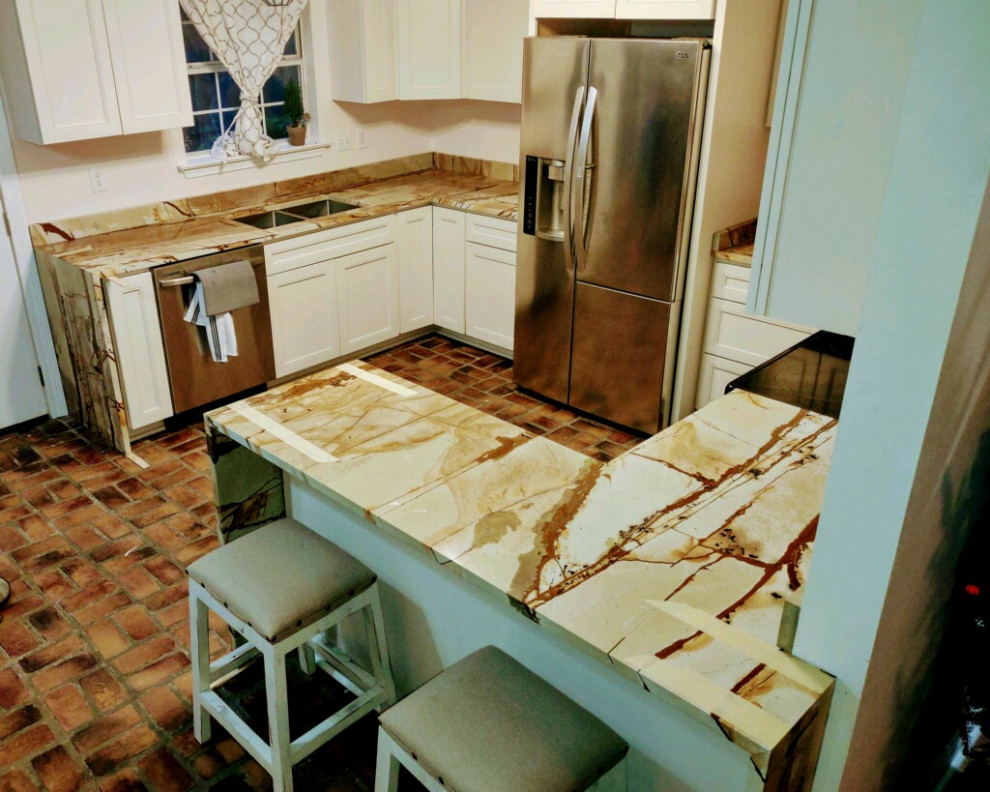 Foto på ett mellanstort eklektiskt beige kök, med en undermonterad diskho, beige skåp, bänkskiva i kvartsit, vitt stänkskydd, tegelgolv, en halv köksö och flerfärgat golv