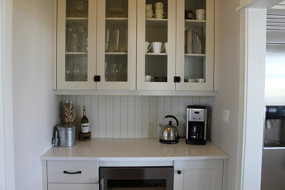 Large transitional l-shaped eat-in kitchen photo in Toronto with an undermount sink, shaker cabinets, white cabinets, quartz countertops, white backsplash, stainless steel appliances and an island