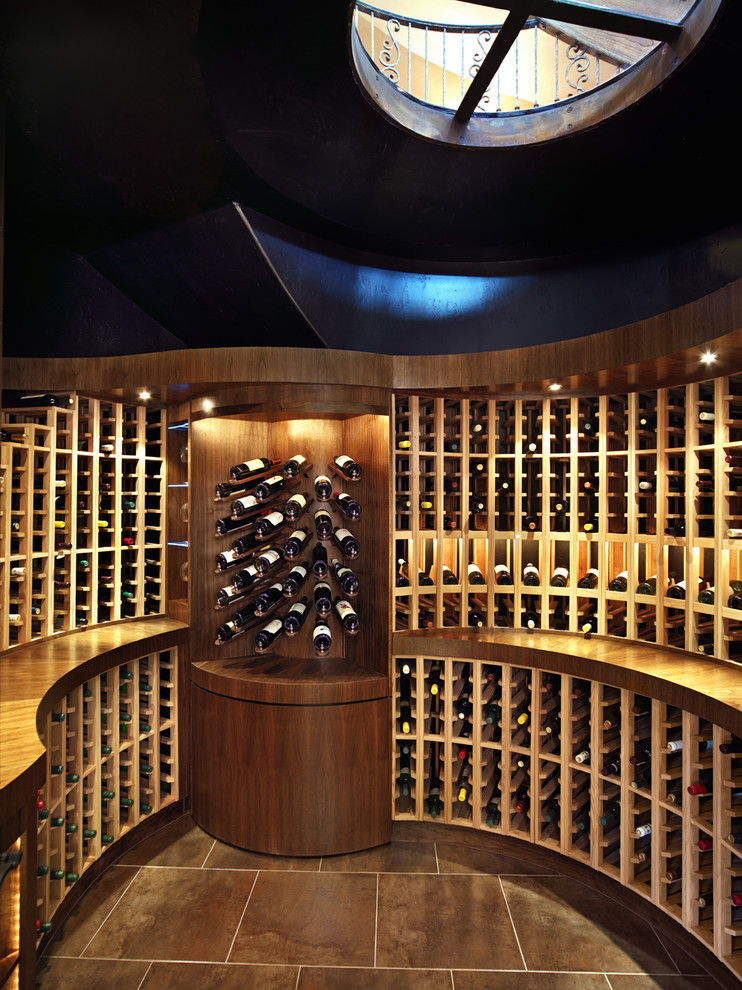 This is an example of a large modern wine cellar in Denver with storage racks, ceramic floors and brown floor.