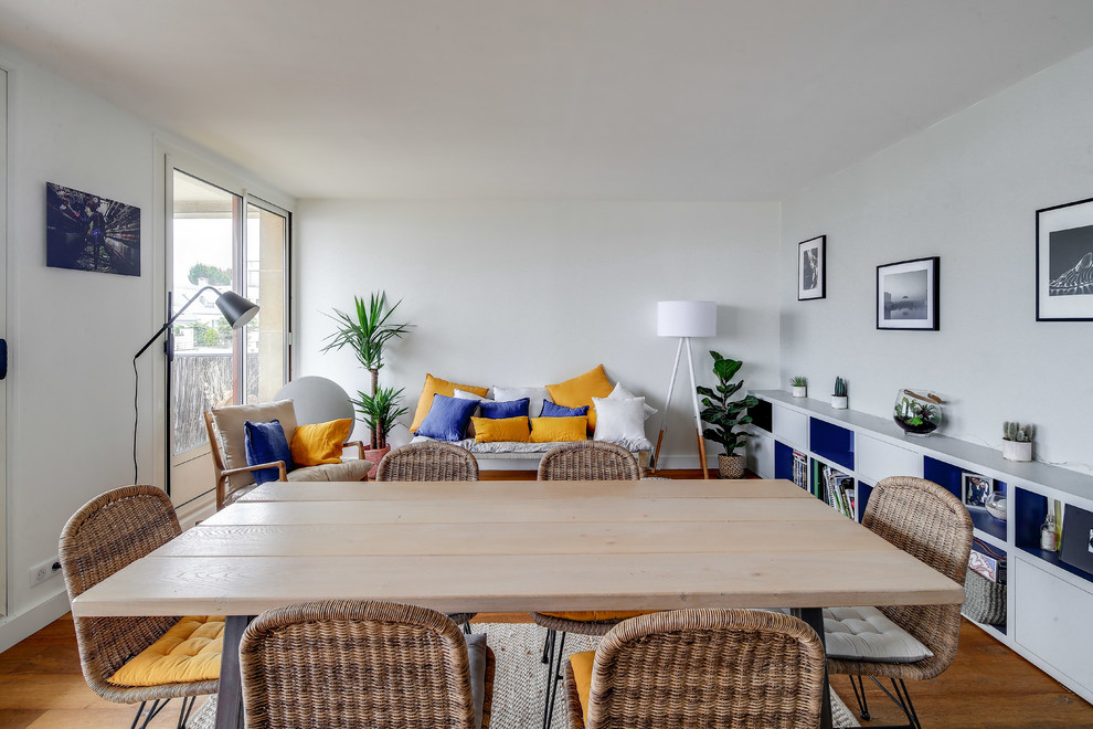 Exemple d'une grande salle à manger ouverte sur le salon tendance avec un mur gris, un sol en bois brun, aucune cheminée et un sol marron.