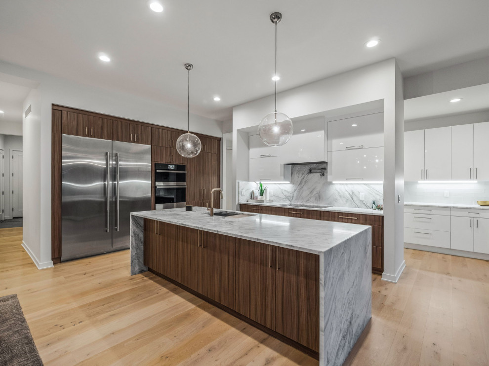 Inspiration for a large modern l-shaped eat-in kitchen in Detroit with a single-bowl sink, flat-panel cabinets, dark wood cabinets, quartzite benchtops, white splashback, engineered quartz splashback, stainless steel appliances, light hardwood floors, with island, beige floor and white benchtop.