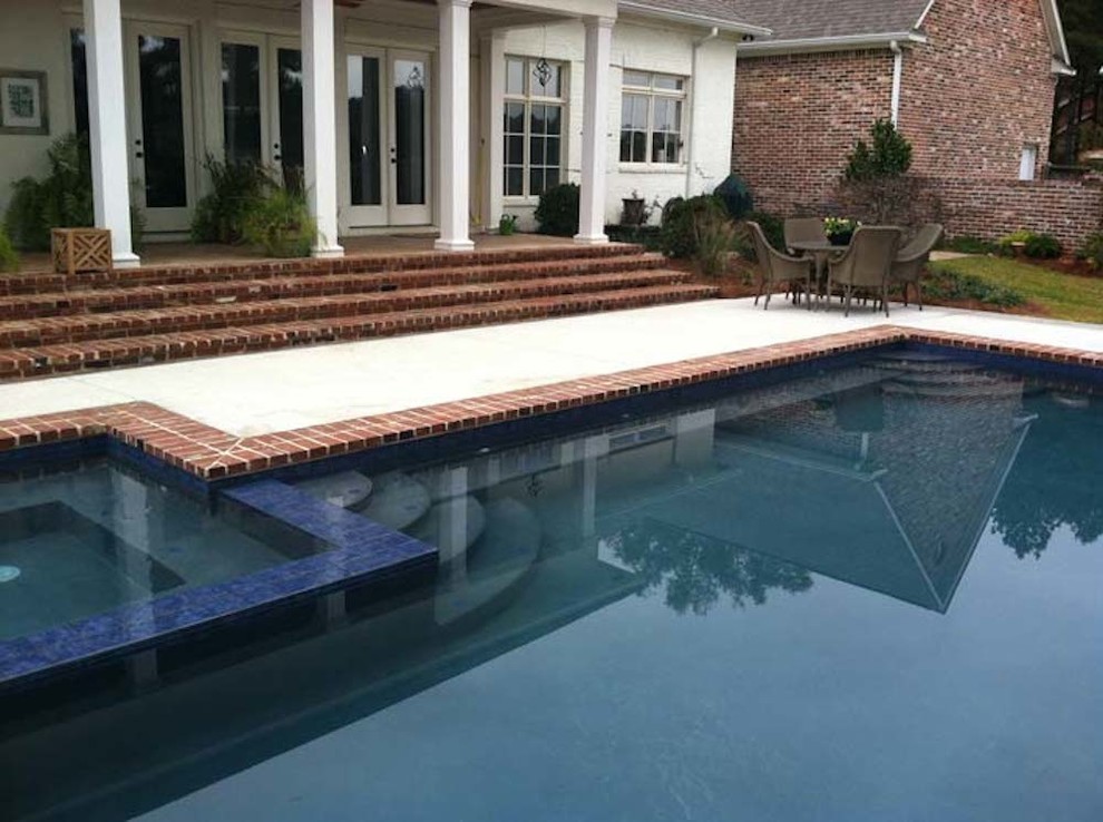 Inspiration for a large timeless backyard brick and custom-shaped lap pool fountain remodel in Jackson