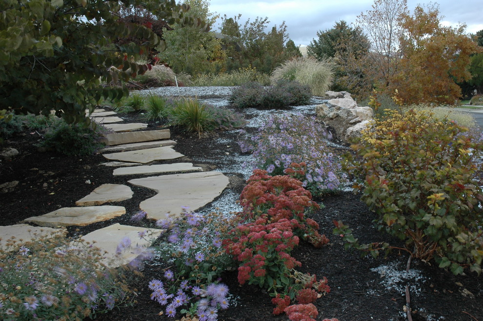 Photo of a large traditional side yard partial sun formal garden for fall in Salt Lake City with natural stone pavers and a garden path.