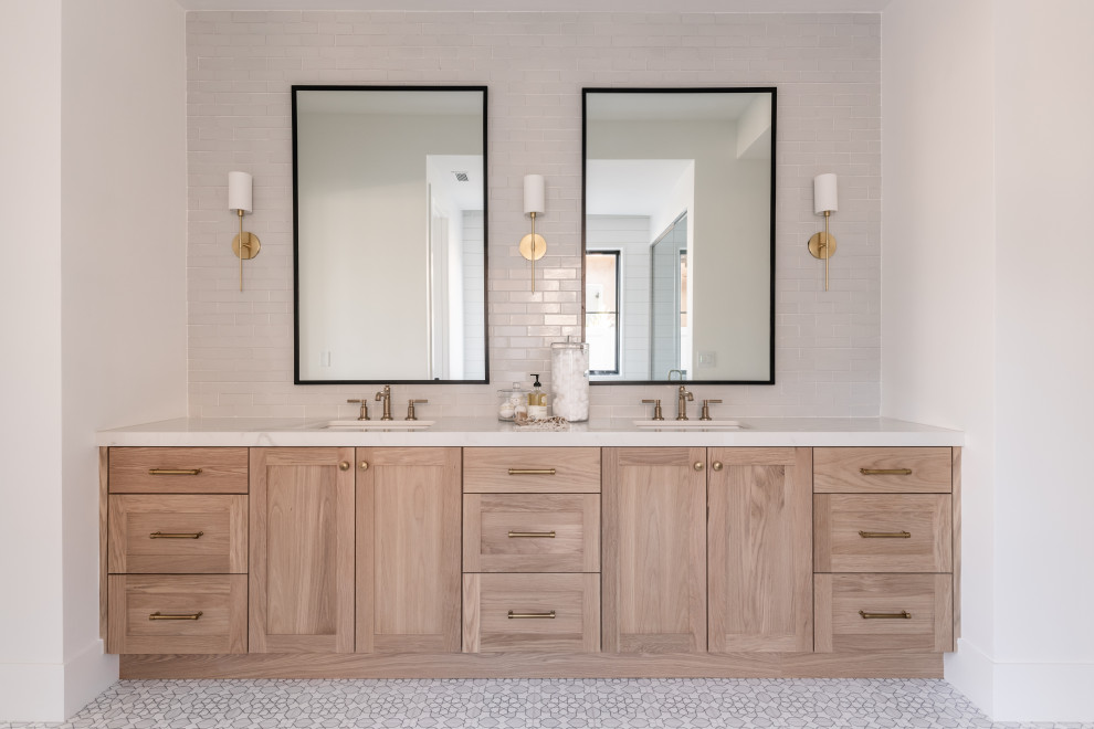 Photo of a large traditional master bathroom in Salt Lake City with medium wood cabinets, a freestanding tub, an alcove shower, gray tile, ceramic tile, ceramic floors, white floor, a hinged shower door, white benchtops, a niche and a double vanity.