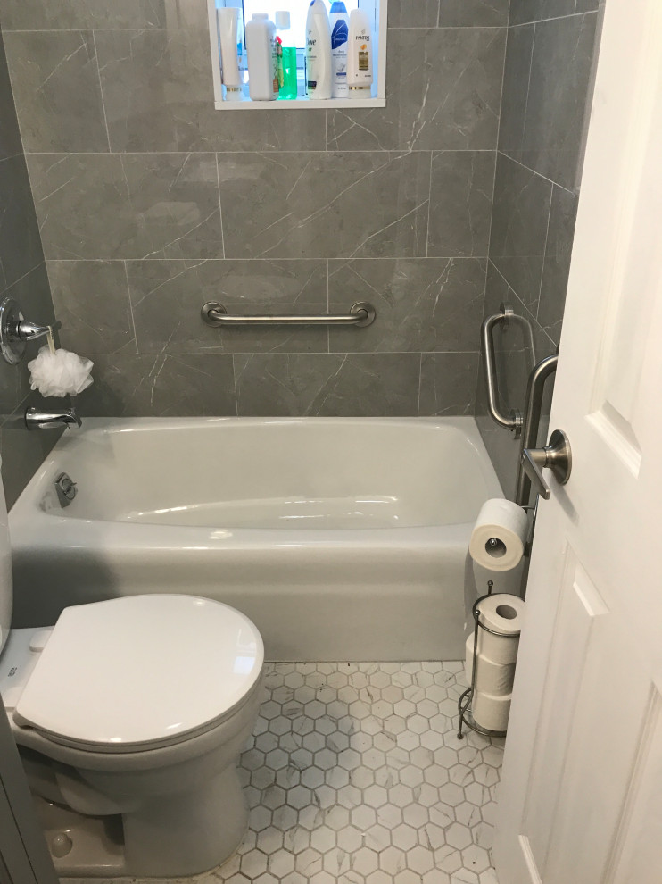 Inredning av ett litet vit vitt en-suite badrum, med möbel-liknande, grå skåp, ett badkar i en alkov, en dusch i en alkov, en toalettstol med separat cisternkåpa, grå kakel, porslinskakel, vita väggar, klinkergolv i porslin, ett nedsänkt handfat, bänkskiva i kvartsit, flerfärgat golv och dusch med duschdraperi