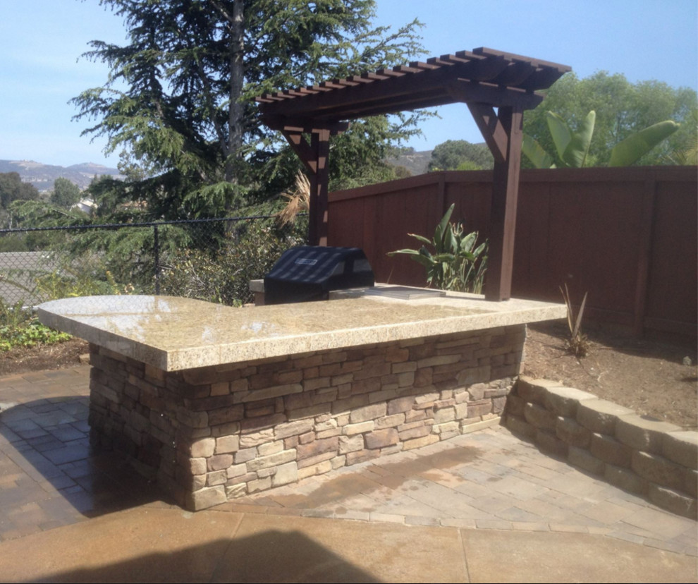 Photo of a mid-sized traditional backyard patio in San Diego with an outdoor kitchen and a pergola.