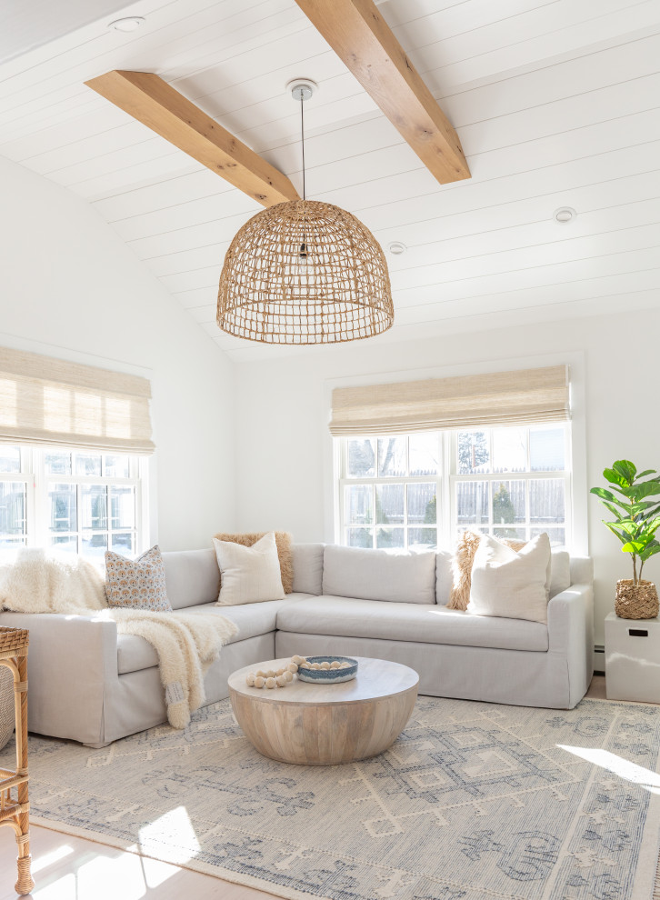 Ejemplo de sala de estar abierta costera grande con paredes blancas, suelo de madera clara, suelo beige, vigas vistas y machihembrado