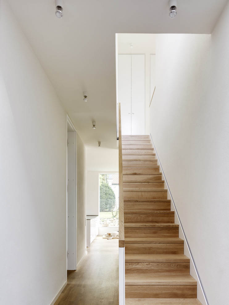 This is an example of a mid-sized contemporary wood straight staircase in Berlin with wood risers.