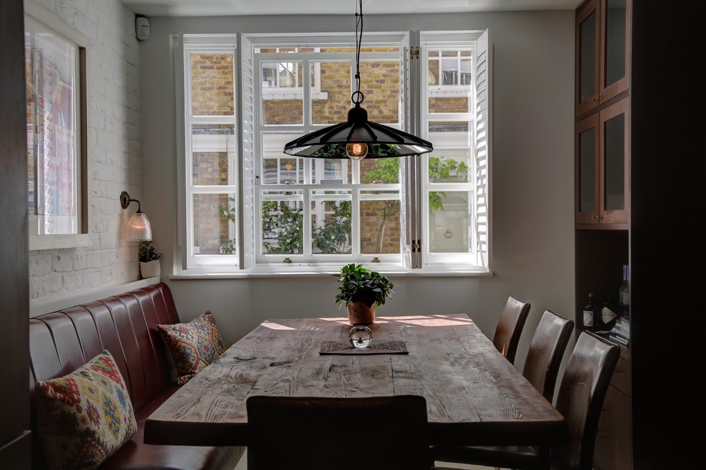Traditional kitchen/dining combo in London with white walls.