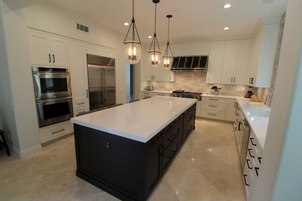 Photo of a large transitional l-shaped kitchen pantry in Orange County with a farmhouse sink, shaker cabinets, white cabinets, granite benchtops, multi-coloured splashback, cement tile splashback, stainless steel appliances, ceramic floors, with island, multi-coloured floor, white benchtop and wood.