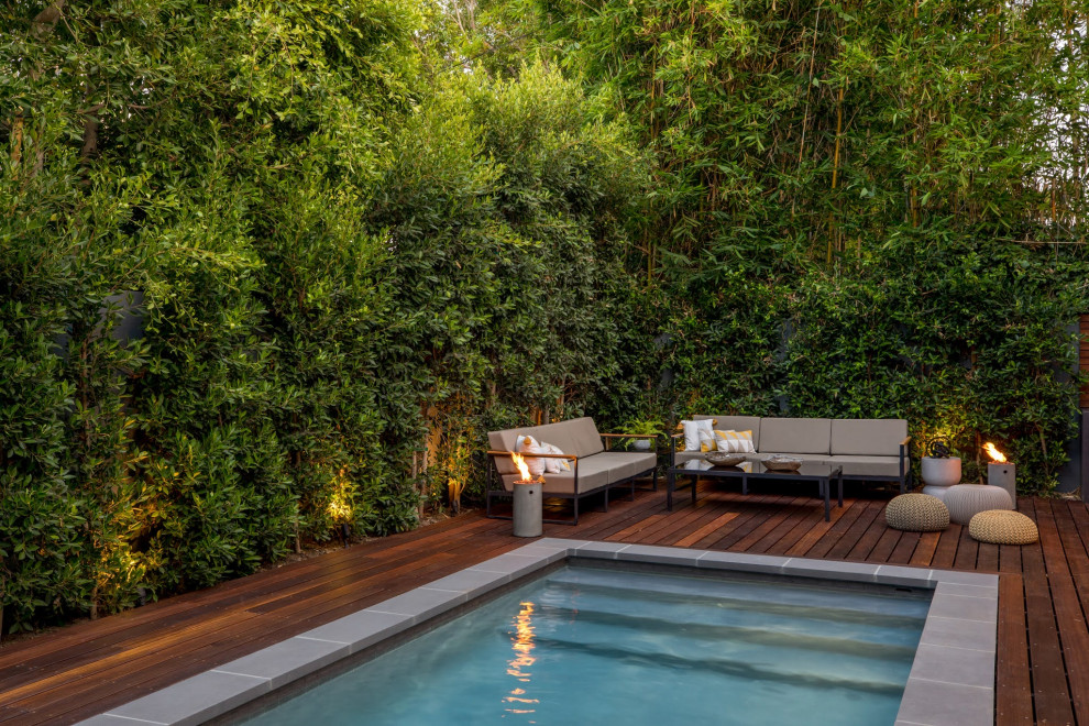 Inspiration pour une piscine arrière nordique de taille moyenne et rectangle avec une terrasse en bois.