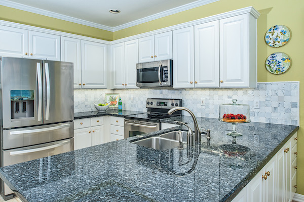 Example of a mid-sized transitional u-shaped eat-in kitchen design in Austin with raised-panel cabinets, white cabinets, white backsplash, marble backsplash, stainless steel appliances, a peninsula and a double-bowl sink