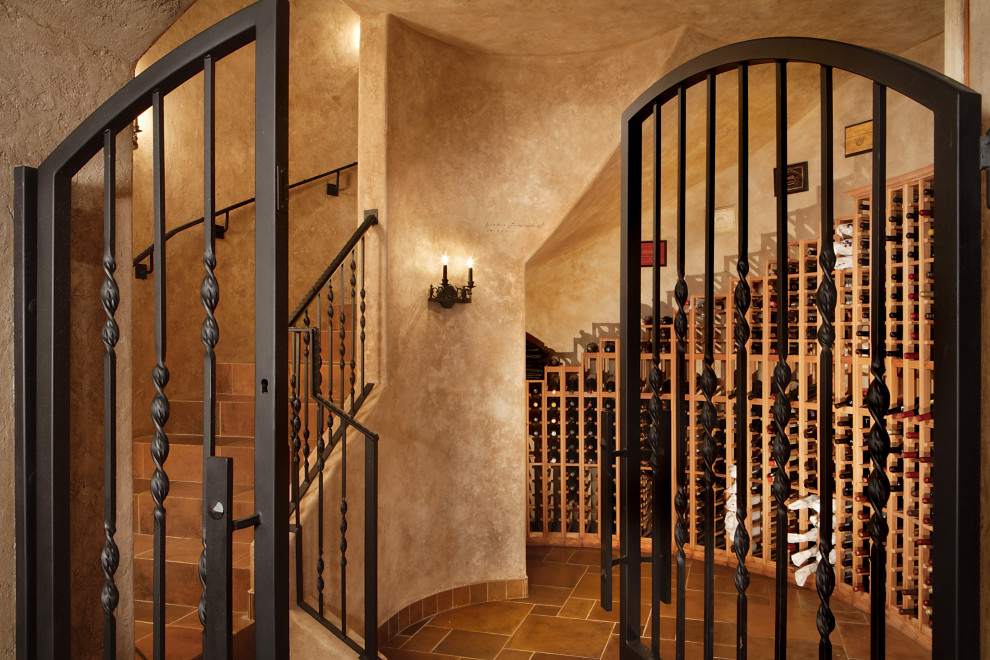 This is an example of an expansive mediterranean wine cellar in Phoenix with diamond bins and multi-coloured floor.