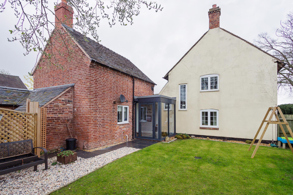 Design ideas for a small and red rustic two floor brick tiny house in West Midlands with a pitched roof and a tiled roof.