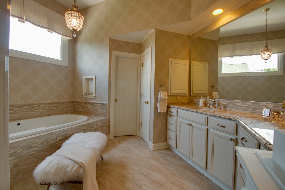 Design ideas for a large contemporary master bathroom in Charlotte with recessed-panel cabinets, beige cabinets, a drop-in tub, an alcove shower, beige tile, limestone, beige walls, limestone floors, an undermount sink, laminate benchtops, beige floor and a hinged shower door.