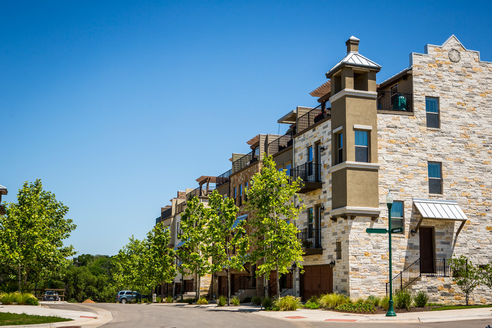 Inspiration for a huge transitional beige three-story stone exterior home remodel in Austin with a hip roof