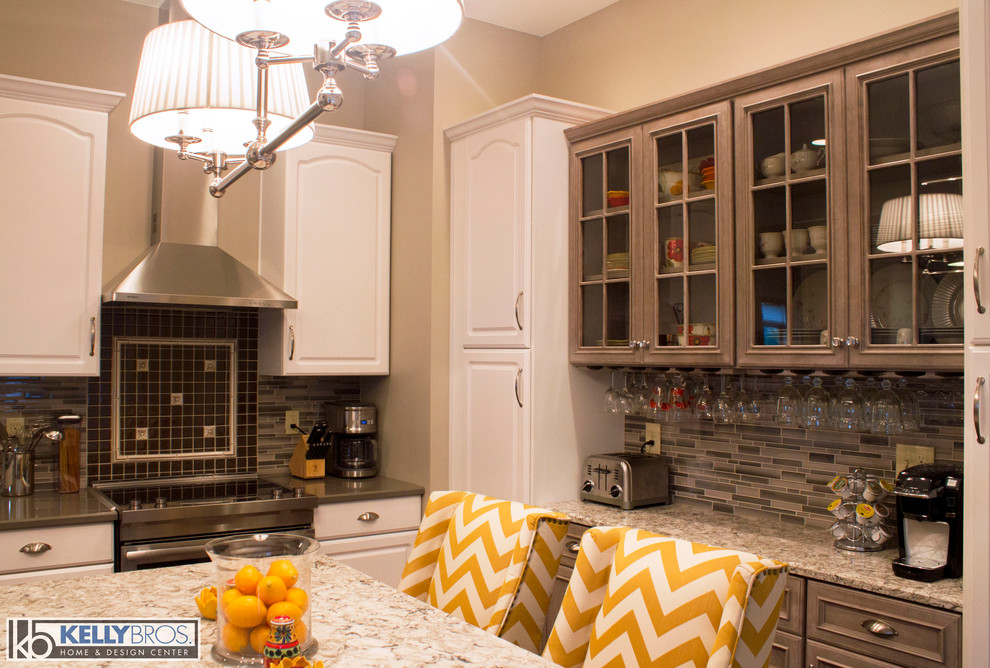 Inspiration for a mid-sized transitional u-shaped dark wood floor eat-in kitchen remodel in Cincinnati with an undermount sink, flat-panel cabinets, gray cabinets, quartz countertops, gray backsplash, glass tile backsplash, stainless steel appliances and an island