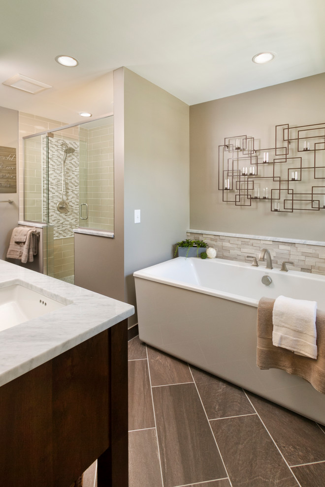 Large contemporary master bathroom in Minneapolis with an undermount sink, shaker cabinets, dark wood cabinets, marble benchtops, a freestanding tub, a double shower, a two-piece toilet, subway tile, beige walls, ceramic floors and beige tile.