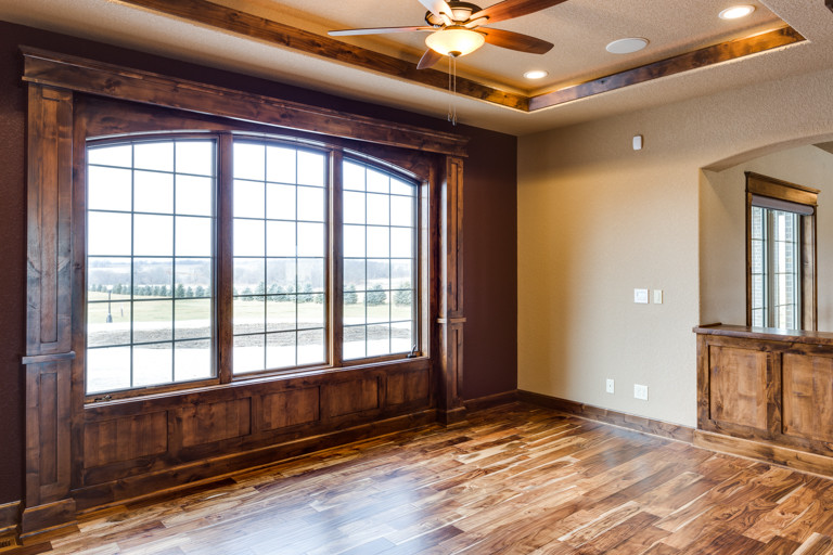 Great room - large rustic medium tone wood floor great room idea with beige walls