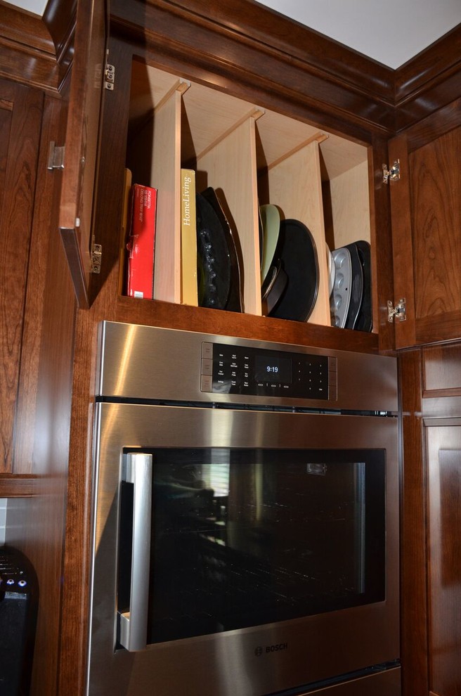 Example of a large transitional l-shaped medium tone wood floor open concept kitchen design in Toronto with an undermount sink, recessed-panel cabinets, dark wood cabinets, quartzite countertops, gray backsplash, glass tile backsplash, stainless steel appliances and an island