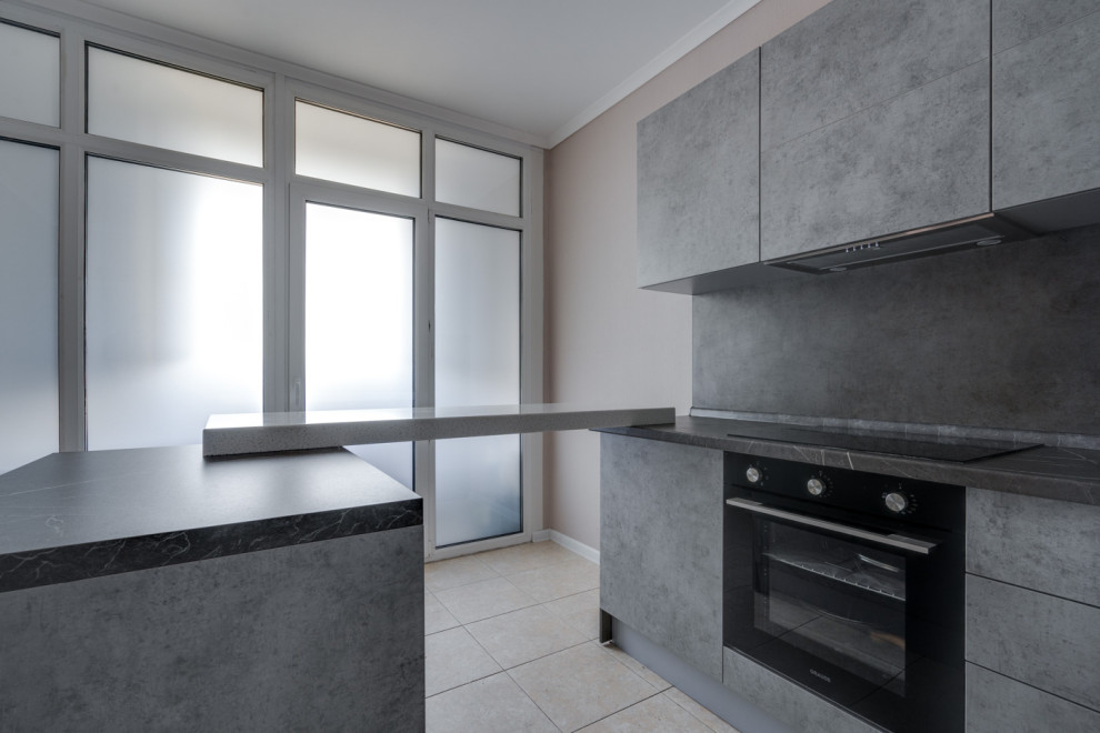 Photo of a mid-sized industrial u-shaped eat-in kitchen in Moscow with an undermount sink, flat-panel cabinets, grey cabinets, solid surface benchtops, grey splashback, black appliances, with island and grey benchtop.