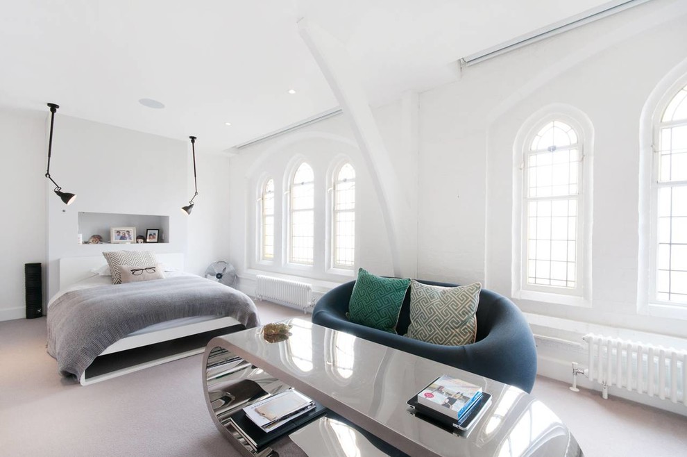 Photo of a contemporary master bedroom in London with white walls and carpet.