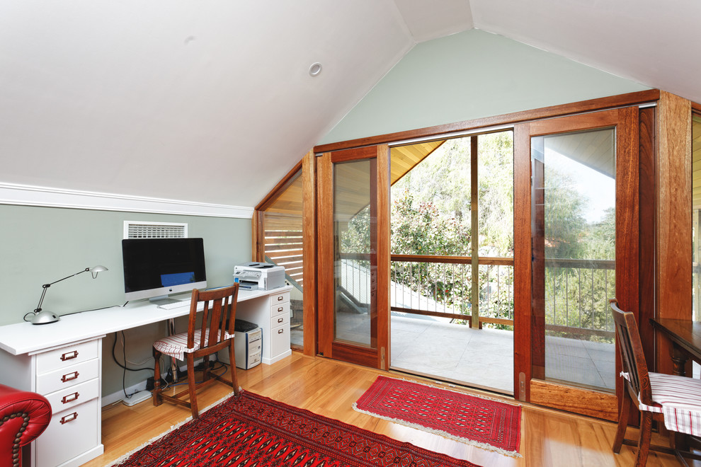 This is an example of a small study room in Perth with light hardwood floors and a freestanding desk.