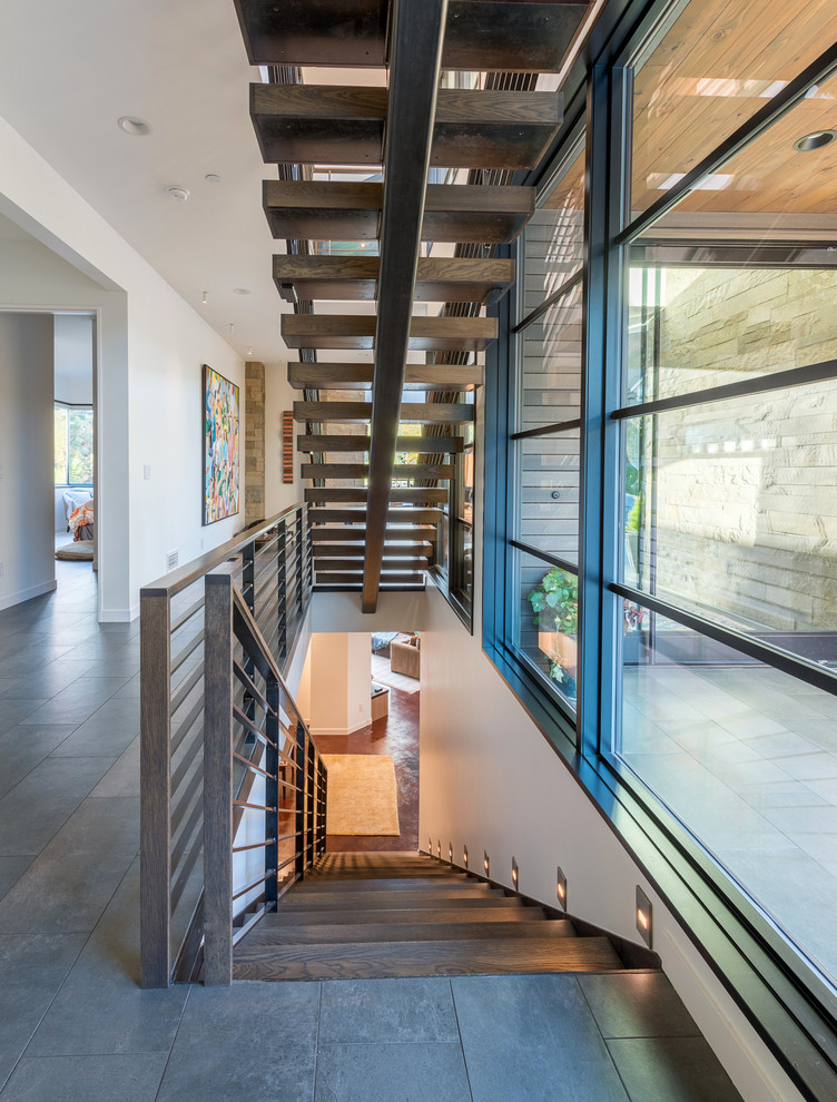 Design ideas for a large contemporary wood straight staircase in Seattle with open risers and metal railing.