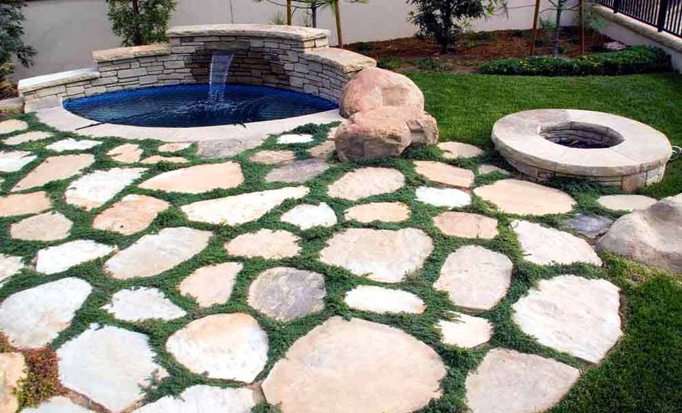 Design ideas for a small traditional backyard round natural pool in Santa Barbara with a hot tub and natural stone pavers.