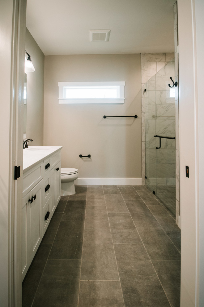 This is an example of a mid-sized modern master bathroom in Atlanta with shaker cabinets, white cabinets, a double shower, a two-piece toilet, gray tile, ceramic tile, beige walls, ceramic floors, a console sink, quartzite benchtops, grey floor, a hinged shower door and white benchtops.