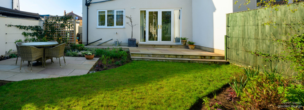 Imagen de jardín moderno pequeño en patio trasero con exposición parcial al sol, adoquines de piedra natural y con madera