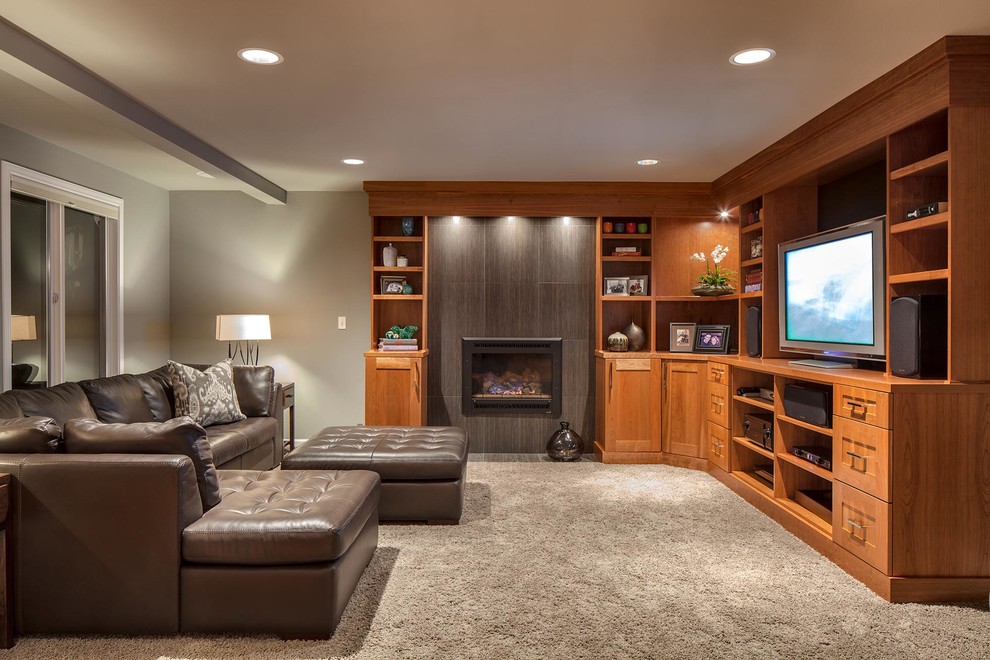 Design ideas for a mid-sized transitional enclosed family room in Seattle with a library, grey walls, carpet, a standard fireplace, a tile fireplace surround, a freestanding tv and grey floor.