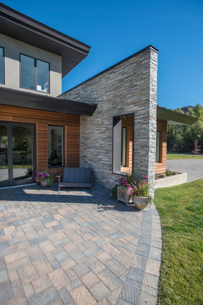 This is an example of a mid-sized modern two-storey grey exterior in Boise with stone veneer and a shed roof.
