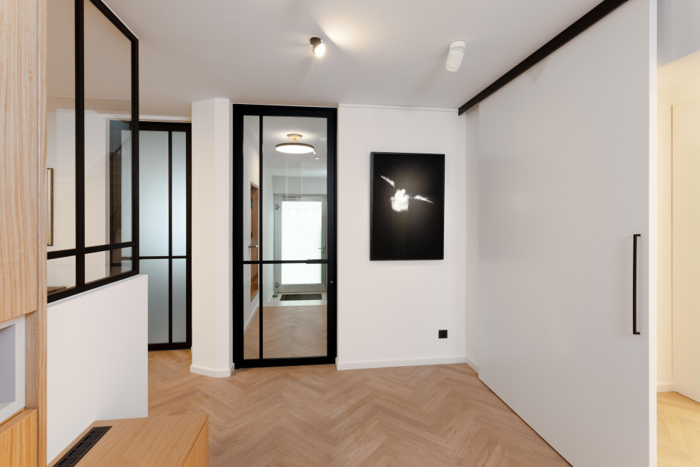 Moderner Flur mit weißer Wandfarbe, hellem Holzboden und Tapetenwänden in Köln