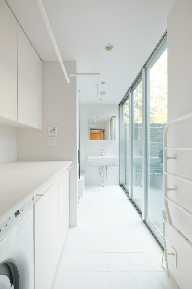 Inspiration for a modern single-wall dedicated laundry room in Tokyo with flat-panel cabinets, white cabinets, white walls, ceramic floors and a concealed washer and dryer.