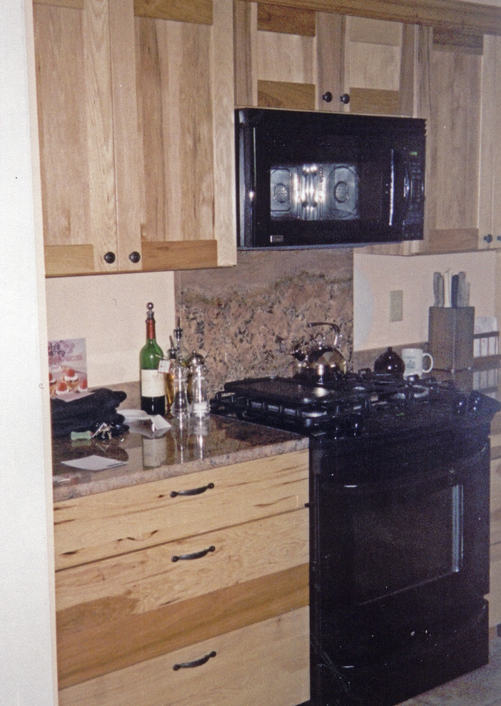 Kitchen - small transitional galley ceramic tile and brown floor kitchen idea with an undermount sink, recessed-panel cabinets, light wood cabinets, marble countertops, brown backsplash, marble backsplash, black appliances, no island and brown countertops
