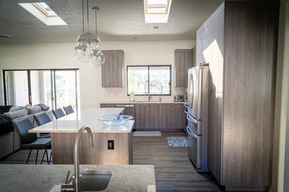 Photo of a contemporary kitchen in Phoenix with flat-panel cabinets, grey cabinets, stainless steel appliances and with island.