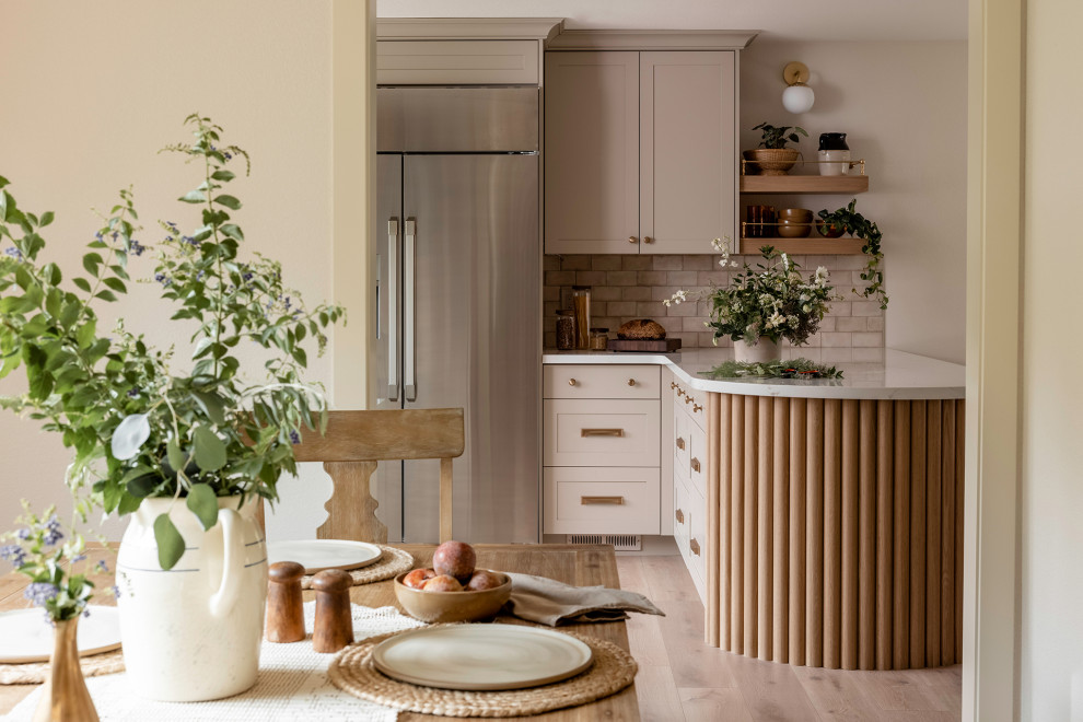 Inspiration for a mid-sized u-shaped separate kitchen in Sacramento with a farmhouse sink, shaker cabinets, beige cabinets, quartz benchtops, beige splashback, ceramic splashback, stainless steel appliances, a peninsula and white benchtop.