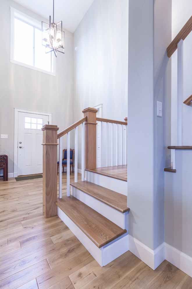 This is an example of a mid-sized arts and crafts wood l-shaped staircase in Albuquerque with painted wood risers and wood railing.