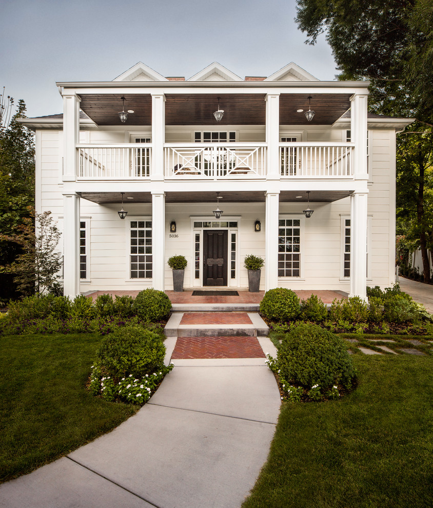 This is an example of a traditional two-storey white house exterior in Salt Lake City with a gable roof and a shingle roof.