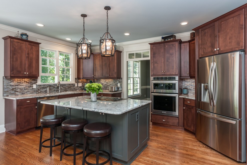 Large contemporary eat-in kitchen in Raleigh with shaker cabinets, medium wood cabinets, granite benchtops, blue splashback, glass sheet splashback, stainless steel appliances, medium hardwood floors, with island and a drop-in sink.