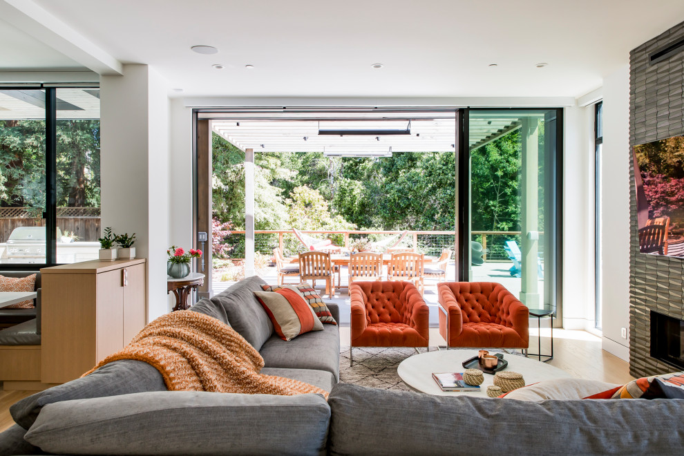 Immagine di un grande soggiorno minimal aperto con pareti bianche, parquet chiaro, TV a parete e pavimento marrone