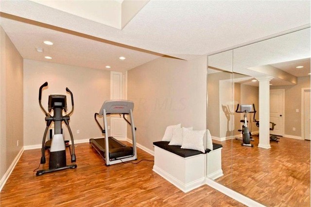 Large elegant light wood floor home yoga studio photo in Columbus with beige walls