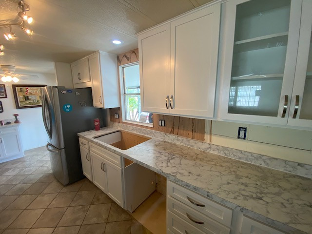 Inspiration for a large galley eat-in kitchen remodel with shaker cabinets, white cabinets, laminate countertops, a peninsula and white countertops