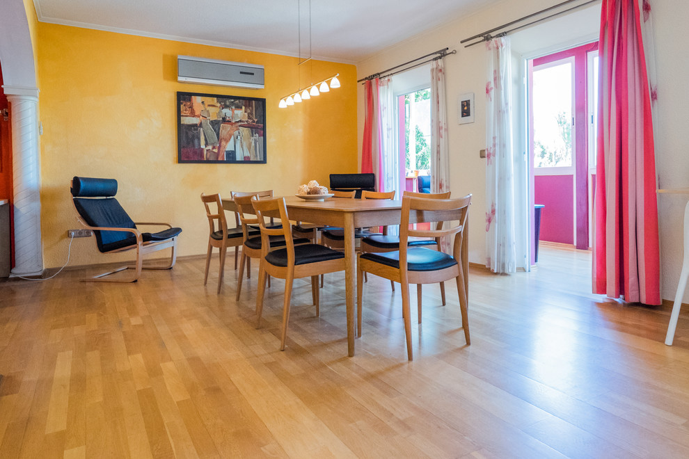 Ejemplo de comedor clásico renovado de tamaño medio cerrado sin chimenea con paredes amarillas y suelo de madera clara