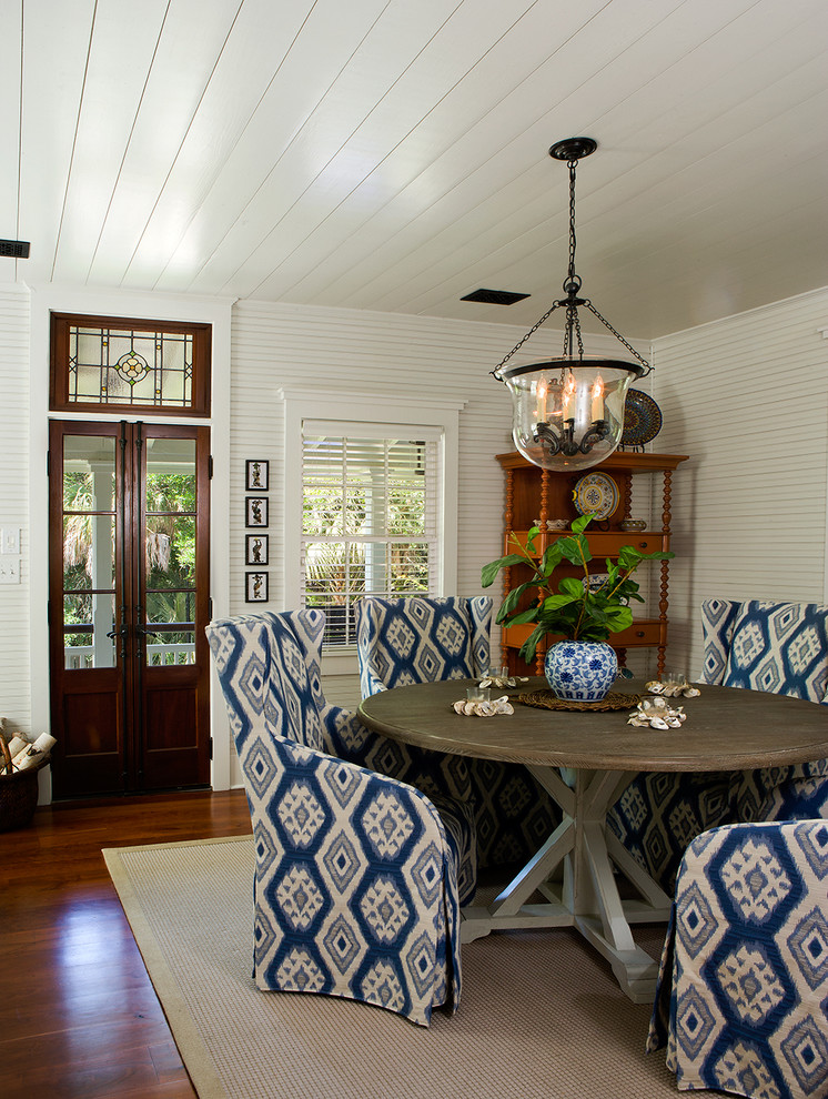 Example of a small beach style medium tone wood floor dining room design in Charleston with white walls